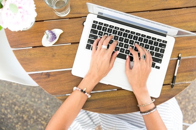 Close-up of hands typing on a laptop keyboard, representing digital marketing strategies